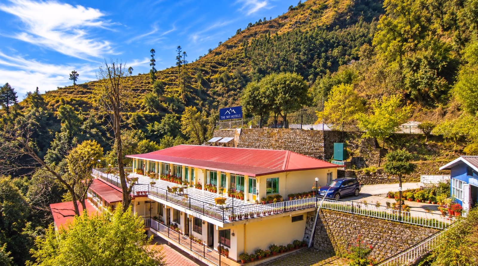 The Sky Hotels seen from across the valley, red roofs against the hillside