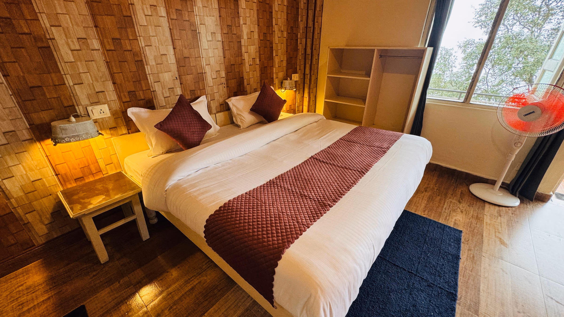 Deluxe room 204 with open shelving beside the bed