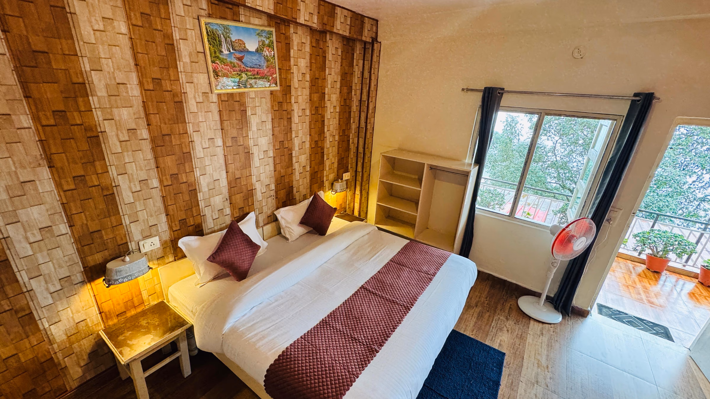 Deluxe room 204 with a wood panelled wall behind the bed