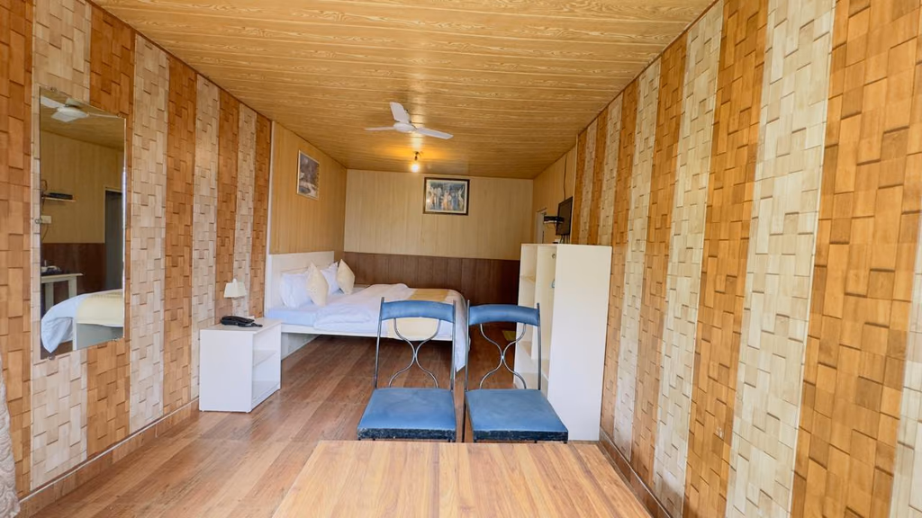 Deluxe room 302 with twin beds under a wood panelled ceiling