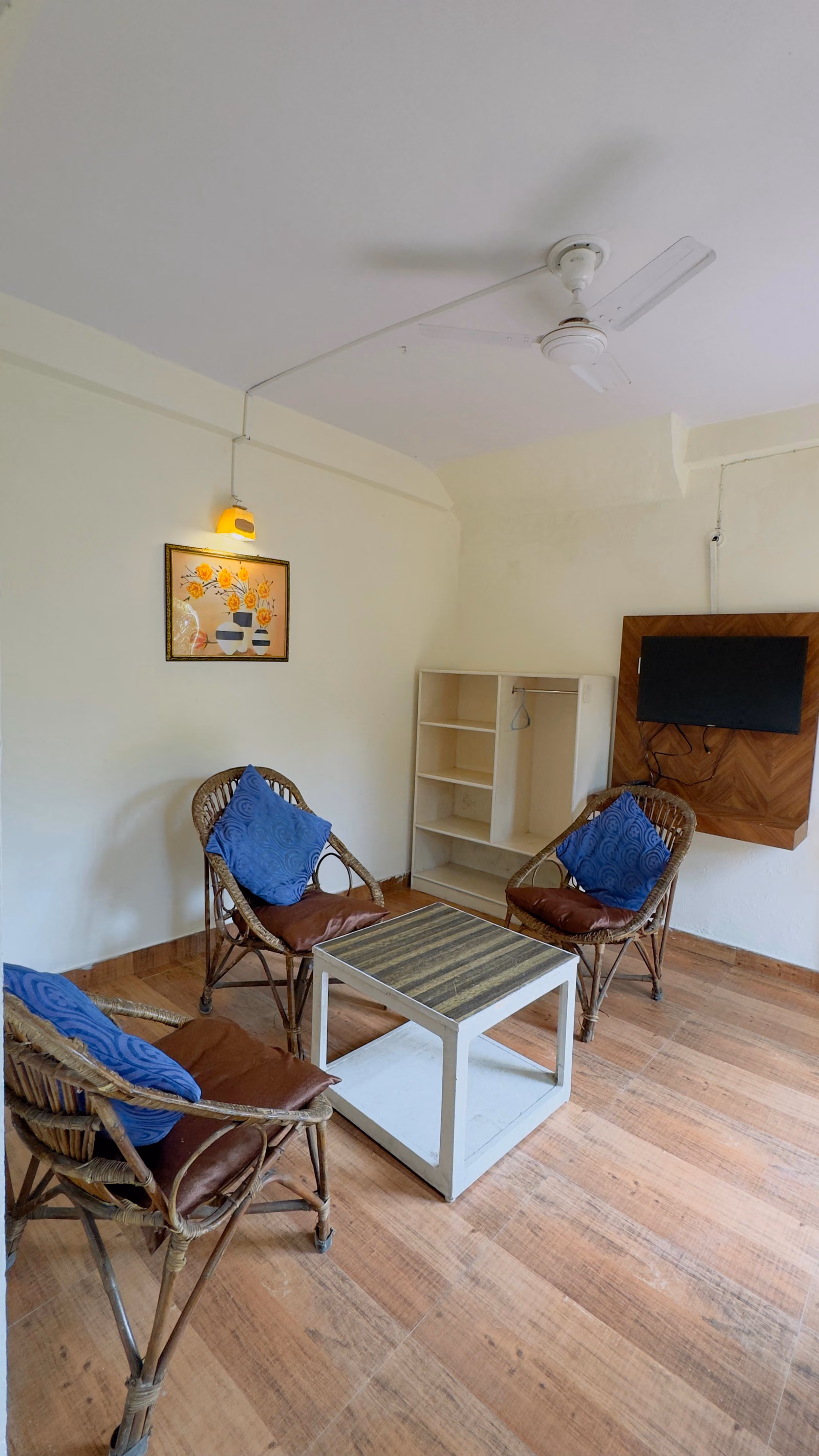Cane chairs and a low table in the seating area of Deluxe room 303