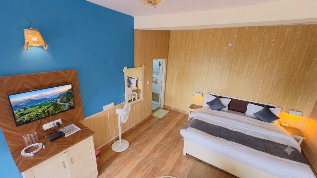 Standard room 202 with a blue feature wall and wooden floor